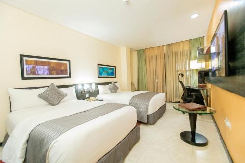 a hotel room with two beds and a flat screen tv at Best Western Premier Accra Airport Hotel in Accra