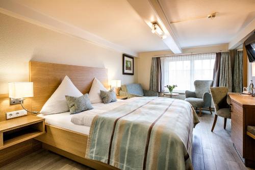 a hotel room with a bed and a desk at Hotel Neuwarft Altbau in Dagebüll