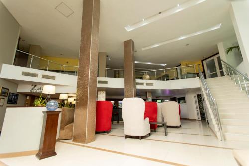 a lobby with red and white chairs and stairs at Best Western Premier Accra Airport Hotel in Accra