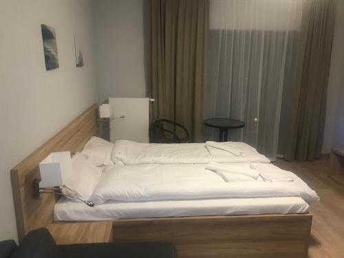 una cama con sábanas blancas en una habitación en Apartament Snow Sun Szklarska Poręba, en Szklarska Poręba