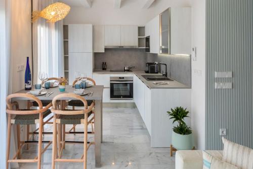 a kitchen with white cabinets and a table and chairs at Playa Vista Mar in Port de la Selva