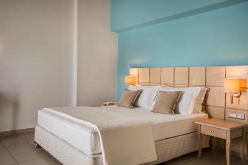 a bedroom with a large white bed with a blue ceiling at Ionian Plaza Hotel & Spa in Argostoli