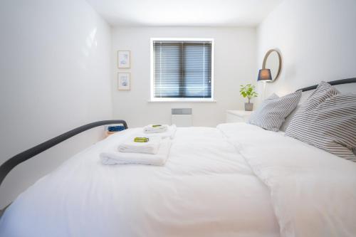 a white bedroom with a large white bed at Stylish Apartment with Private Parking in Cardiff