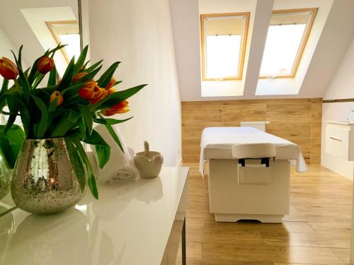 a room with a vase of flowers on a table at Hotel Santa Monica in Mikołajki