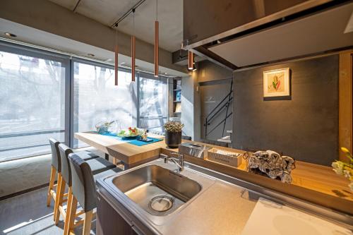 a kitchen with a sink and a table with chairs at trive sakae 最大7名宿泊可能 矢場町駅徒歩3分 栄 大須観音スグ in Nagoya