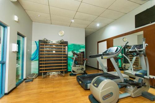 a gym with a treadmill and a elliptical machine at Best Western Premier Accra Airport Hotel in Accra