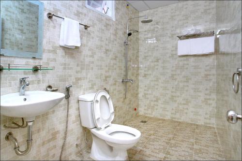 y baño con aseo, lavabo y ducha. en Cosy House Homestay, en Hoi An