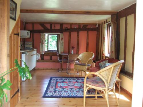 a living room with chairs and a table at Snooky's Barn at Brook Cottage in Graffham