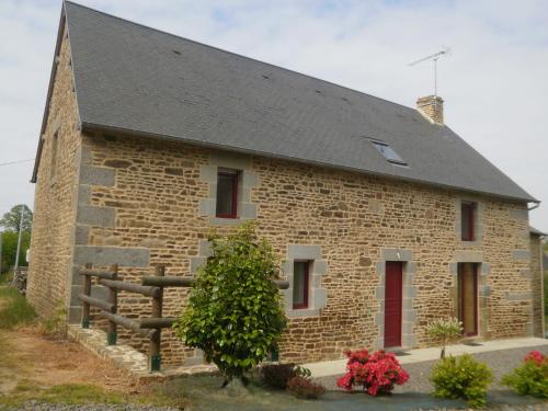 una casa in pietra con tetto nero e porte rosse di Modern Cottage in Normandy with Large Garden a Isigny-le-Buat