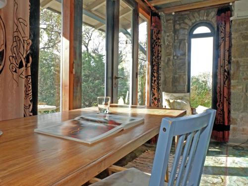 a dining room with a wooden table and chairs at To The Garden in Aliki