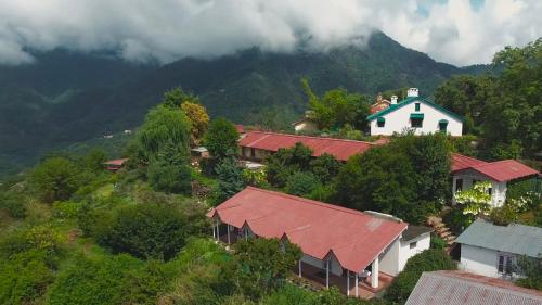 a group of houses on a hill with a mountain at Neemrana's - Ramgarh Bungalows in Rāmgarh
