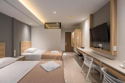 a hotel room with two beds and a flat screen tv at Haven 35 in Bangkok