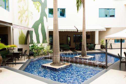 a pool in the middle of a building with palm trees at Best Western Premier Accra Airport Hotel in Accra