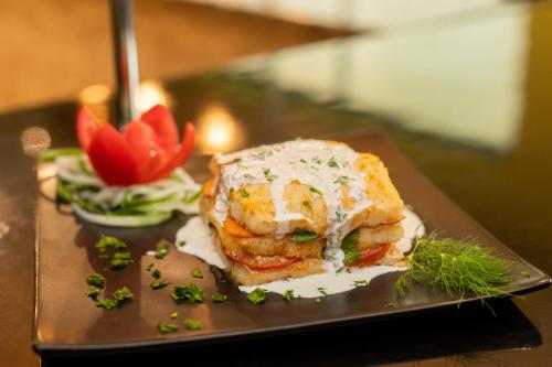 a plate of food with a sandwich on a table at Best Western Premier Accra Airport Hotel in Accra