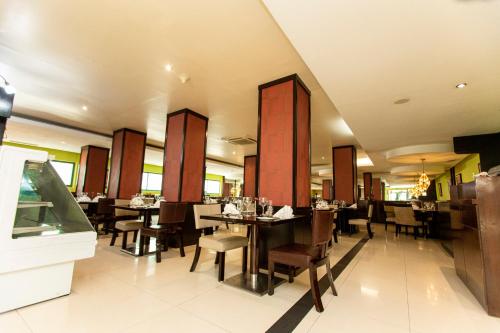 a dining room with tables and chairs in a restaurant at Best Western Premier Accra Airport Hotel in Accra