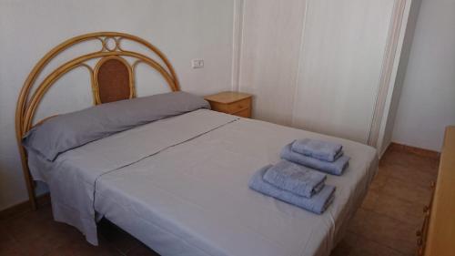1 dormitorio con 1 cama con 2 toallas en Marina De La Torre, en Mojácar