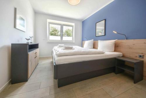 コルスヴァントにあるSonnenpark 03 - mit Saunaの青い壁のベッドルーム1室(大型ベッド1台付)