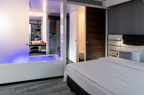 a bedroom with a large bed and a bath tub at Airport Plaza Hotel Hamburg in Norderstedt