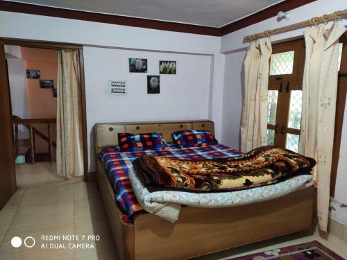 a bedroom with a bed and a window at Vamoose Badri Villa in Joshīmath