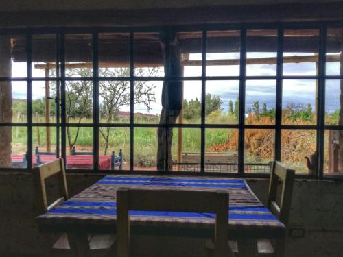 a table and chairs in a room with a large window at Chakana Hospedaje Rural in Villa Unión
