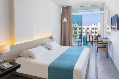 a hotel room with a bed and a balcony at Mayfair Hotel formerly Smartline Paphos in Paphos City