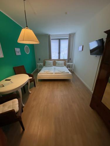 a room with a bed and a table in it at Gästehaus Lavendel in Flensburg
