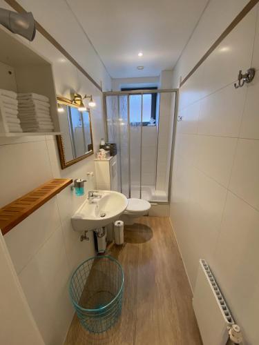 a white bathroom with a sink and a shower at Gästehaus Lavendel in Flensburg