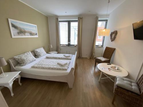 1 dormitorio con 1 cama, mesa y sillas en Gästehaus Lavendel, en Flensburg