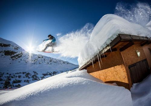 a man flying through the air while riding a snowboard at Rila Hotel Borovets in Borovets