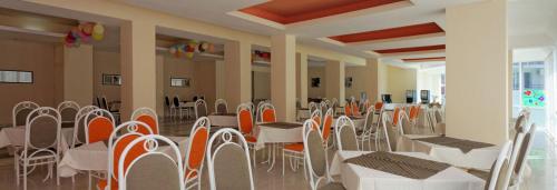 a dining room with tables and chairs in a building at Club Hotel Vedren in Kranevo