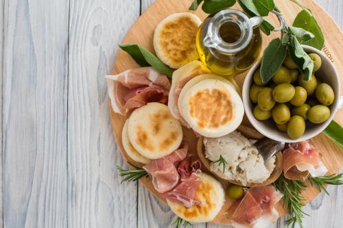a plate of food with eggs ham and olives at Meditur Hotel Bologna in Bologna