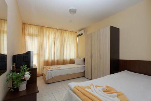 Cette chambre comprend deux lits et une télévision. dans l'établissement Club Hotel Vedren, à Kranevo