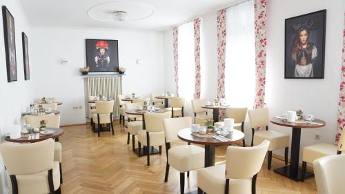 バーデン・バーデンにあるホテル ビッショフのテーブルと椅子が備わるレストラン