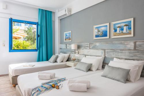 a bedroom with two beds and a window at Nana Angela Apartments in Hersonissos