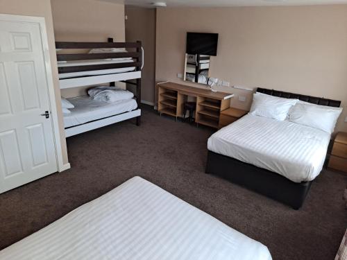 a hotel room with two beds and a desk at The Beechfield Hotel in Blackpool