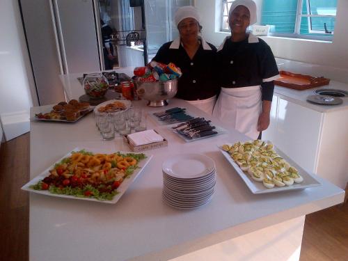 two women standing in a kitchen with a table of food at Goulden Street Guest House in East London