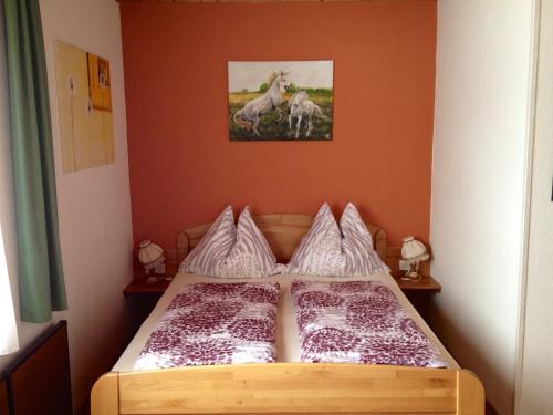 1 dormitorio con 1 cama con una foto de caballos en la pared en Ferienwohnungen Pernull, en Waidegg