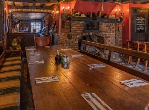 a long wooden table in a restaurant with a fireplace at The Leagate Inn in Coningsby