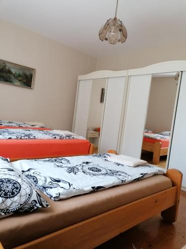 a bedroom with two beds and a chandelier at Kerka Szállás in Kerkabarabás