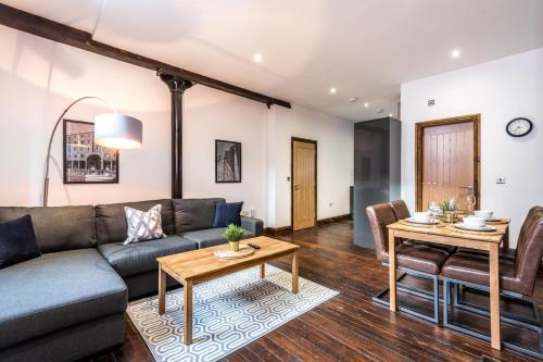 a living room with a couch and a table at 27 Stanley Street Aparthotel by UStay in Liverpool