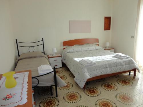 1 Schlafzimmer mit 2 Einzelbetten und einem Teppich in der Unterkunft Baciati dal sole - Appartamento fronte spiaggia in Porto Empedocle