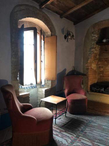 a living room with two chairs and a table at La Locanda del Loggiato in Bagno Vignoni