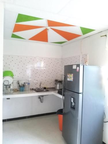 a kitchen with a refrigerator and a counter top at La Morena Hospedaje in Acacías