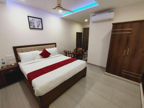 a bedroom with a bed and a cabinet in a room at Kings Court Guest Inn in Nellore