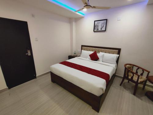 a bedroom with a large bed and a chair at Kings Court Guest Inn in Nellore