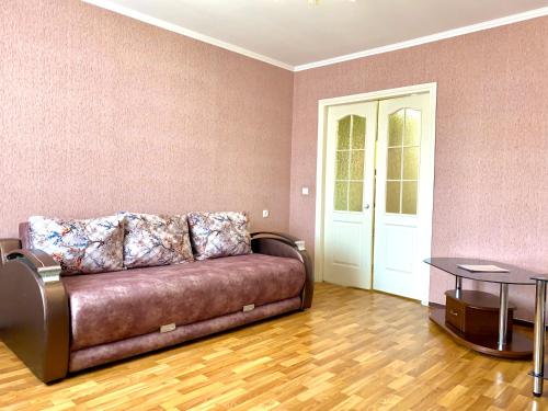 a living room with a brown couch and a table at ApartPoltava ЦЕНТР Полтави, Простора та зручна квартира біля ПУЕТ, 2-ОКРЕМІ КІМНАТИ, звітна документація для відрядження in Poltava