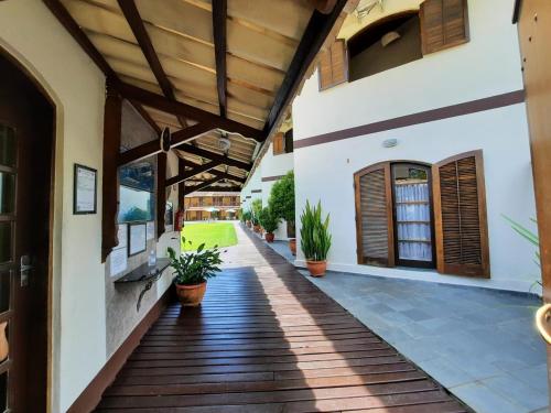 a porch of a house with potted plants at Pousada e Residencial Villafranca in Boicucanga