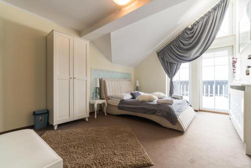 a bedroom with a bed and a large window at Dworek Rajska Góra in Wejherowo