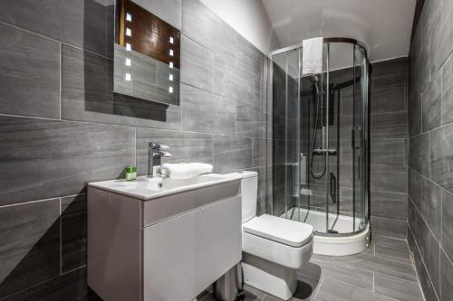 a bathroom with a toilet and a sink and a shower at 27 Stanley Street Aparthotel by UStay in Liverpool