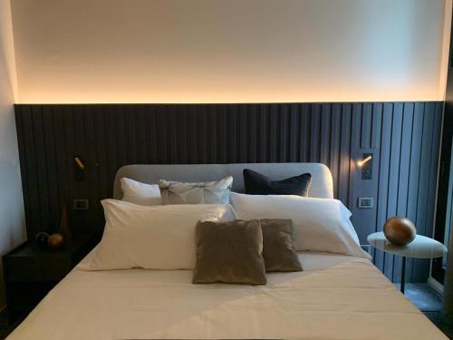 a large bed with white sheets and pillows at Bv hotel in Brignano Gera dʼAdda